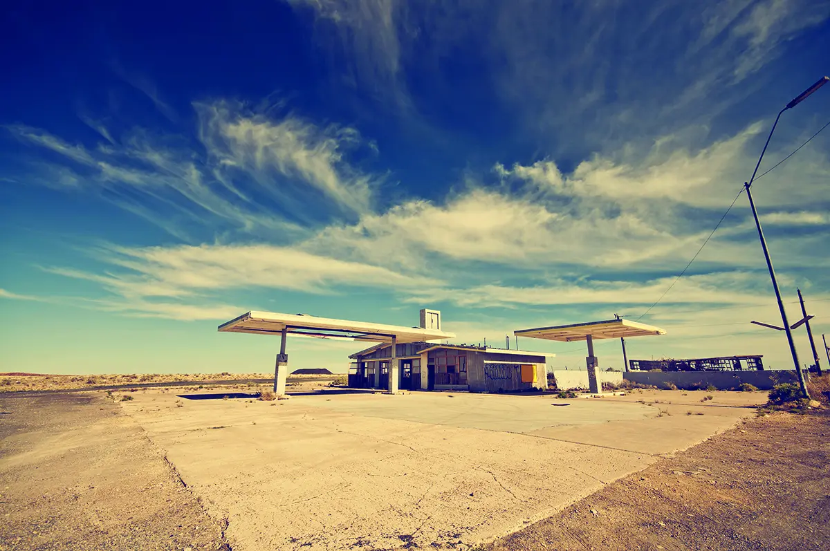 Exterior of an abandoned gas station lot in a rural desert area